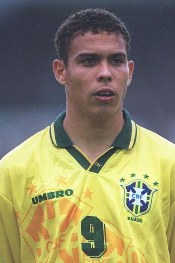 a young man in a soccer uniform is looking at the camera and has his mouth open