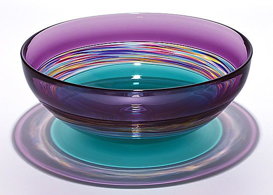 a purple glass bowl sitting on top of a plate