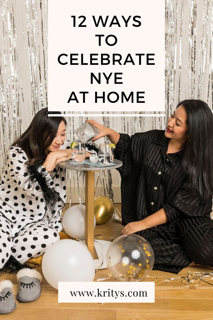 two women sitting at a table with balloons and confetti in front of them