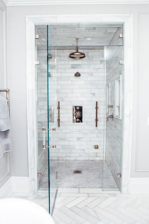 a walk in shower sitting next to a bath tub