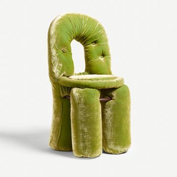 a green velvet chair and footstool sitting next to each other