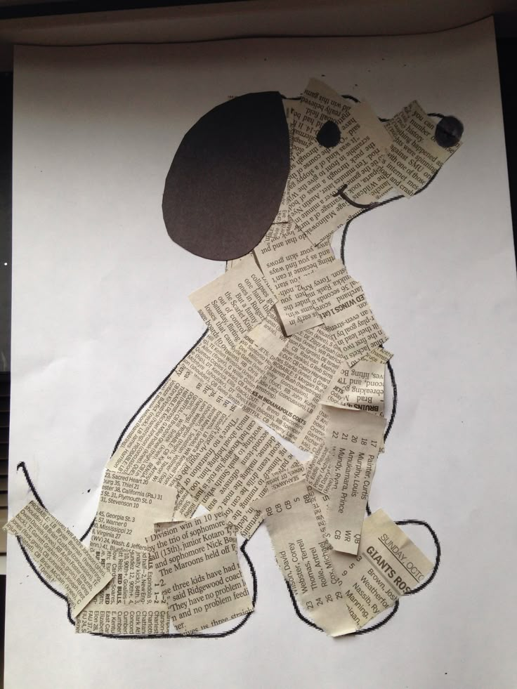 a dog made out of book pages sitting on top of a piece of paper