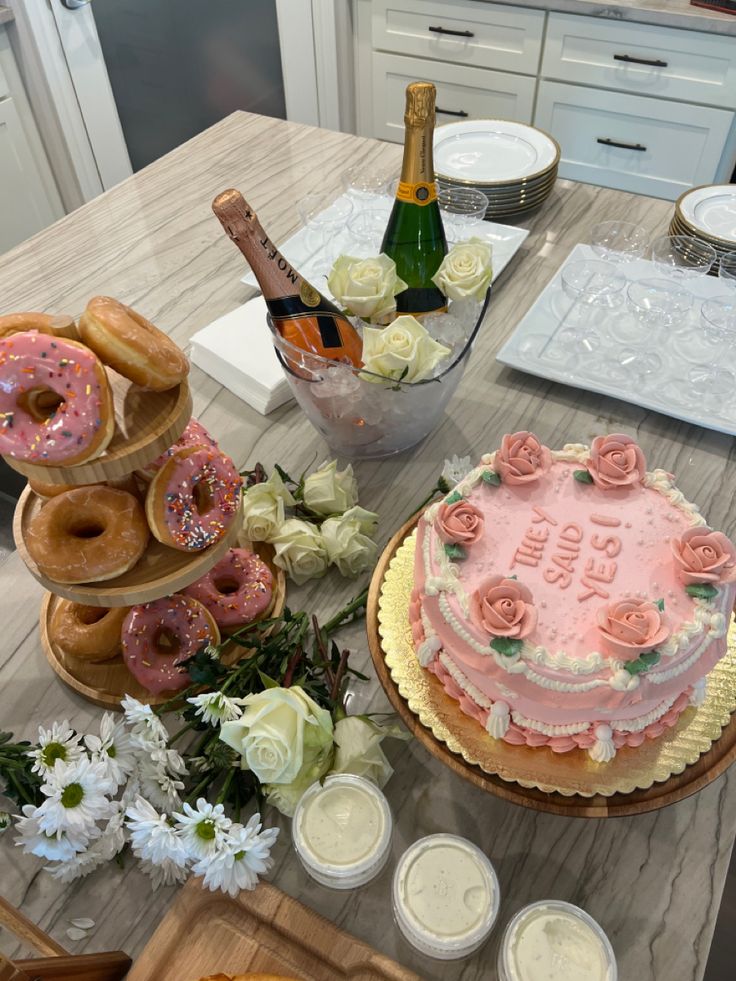 there is a cake and doughnuts on the table with flowers in vases