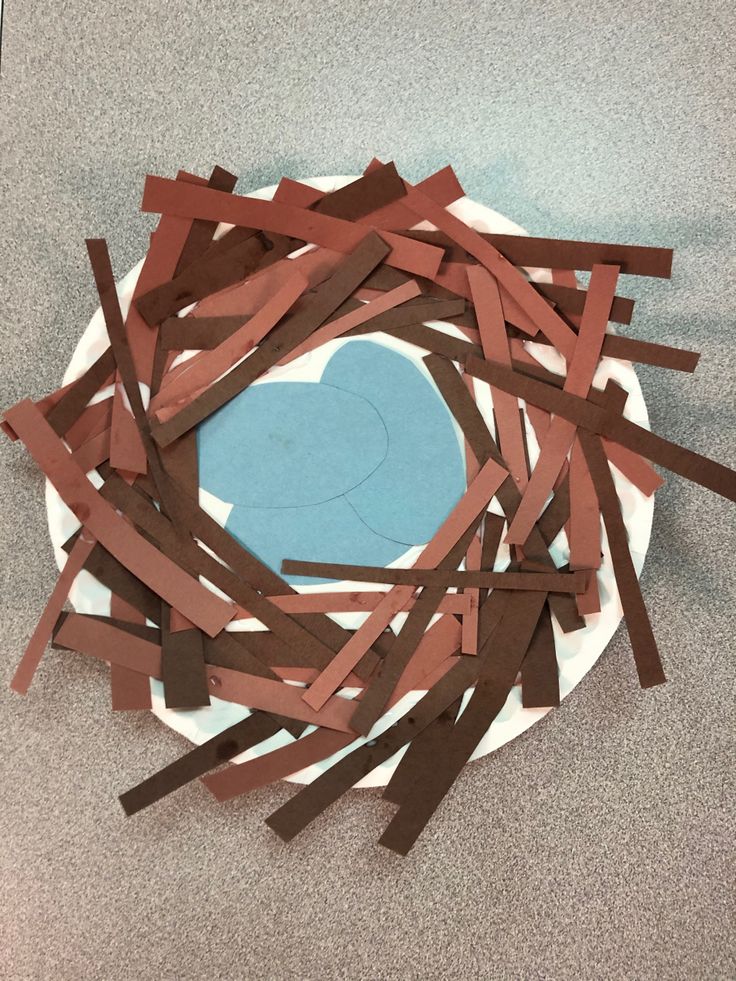 a paper plate filled with strips of brown tape on top of a white and blue plate