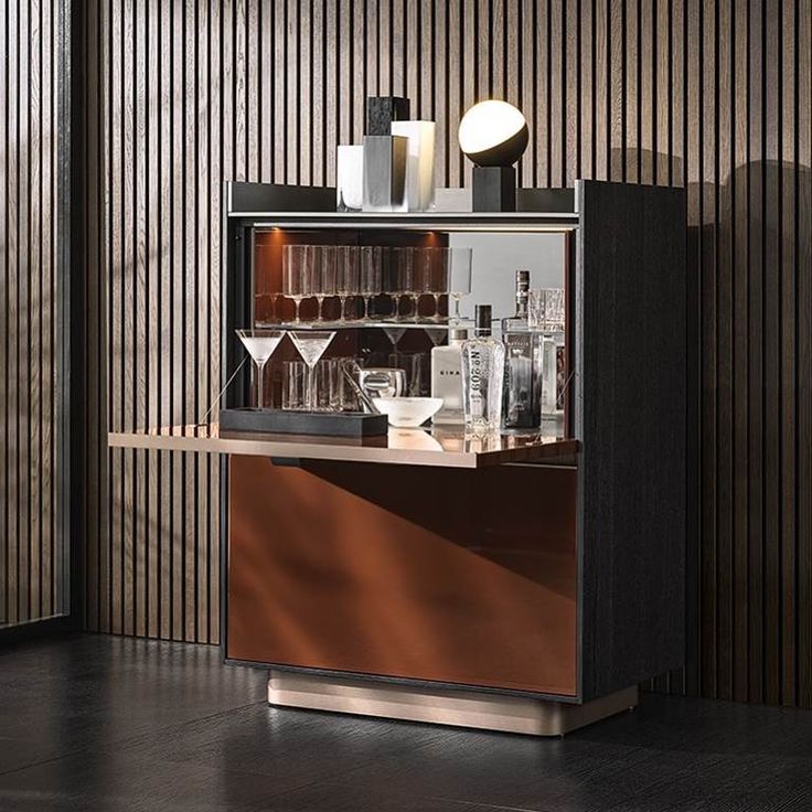 a bar with several glasses and bottles on the counter in front of a striped wall