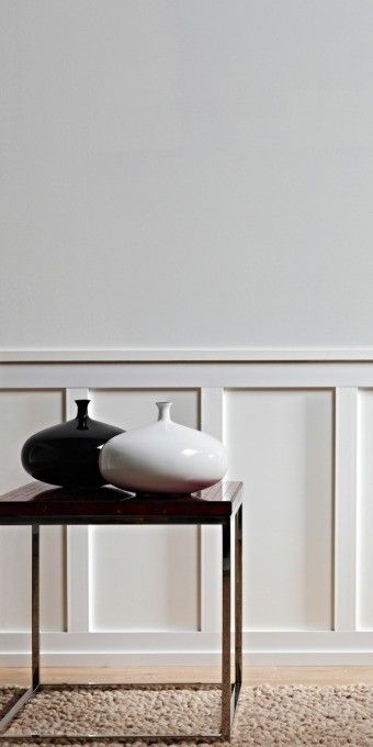 two black and white vases sitting on top of a table