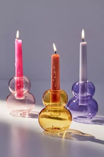 three different colored candles sitting next to each other