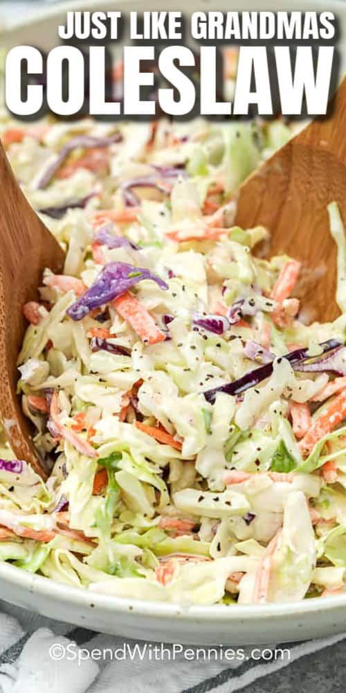 two wooden spoons in a bowl filled with coleslaw