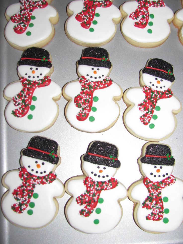 decorated cookies in the shape of snowmen with hats and scarfs