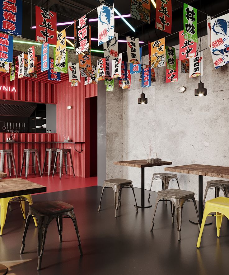 an empty restaurant with tables and stools in front of colorful banners hanging from the ceiling