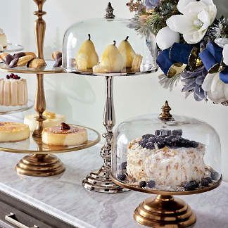 three tiered trays filled with cakes and desserts on top of a marble counter