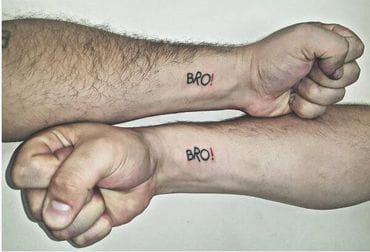 two people with tattoos on their arms holding each other's hands and the words broi written in black ink