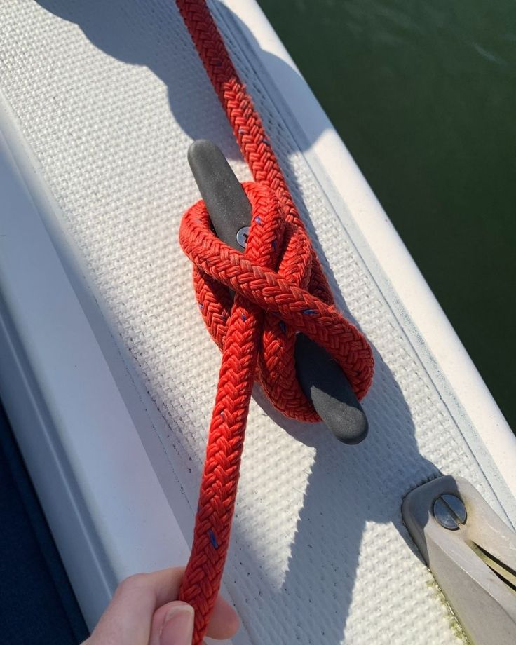 someone is holding on to a red rope attached to a boat