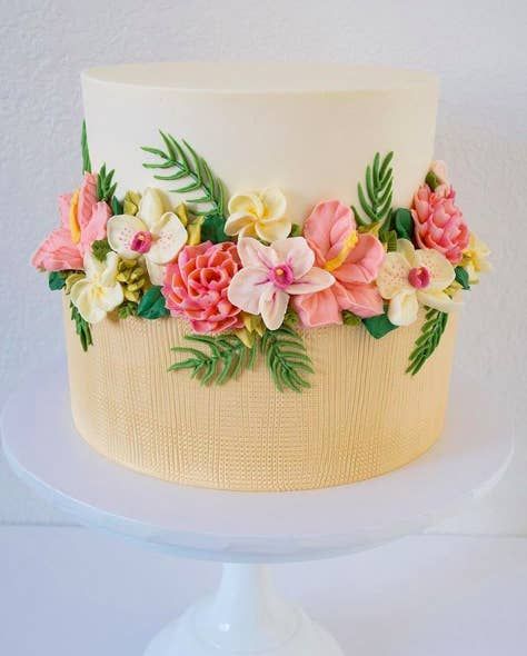 a white cake with pink and yellow flowers on it