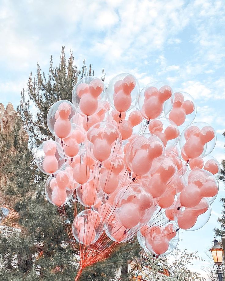 a bunch of pink balloons floating in the air