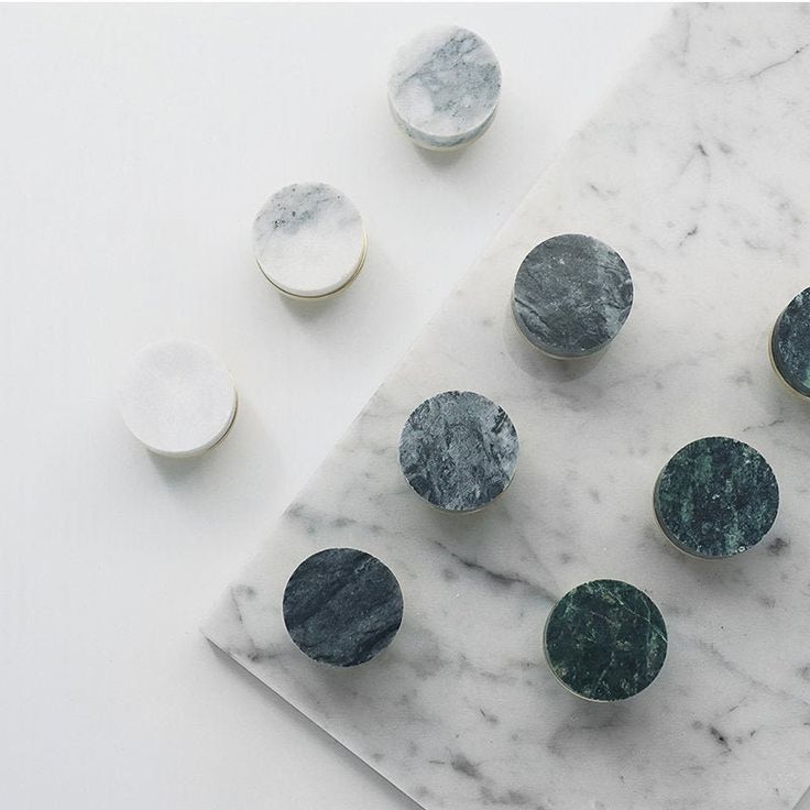 marble and metal buttons sitting on top of a white table