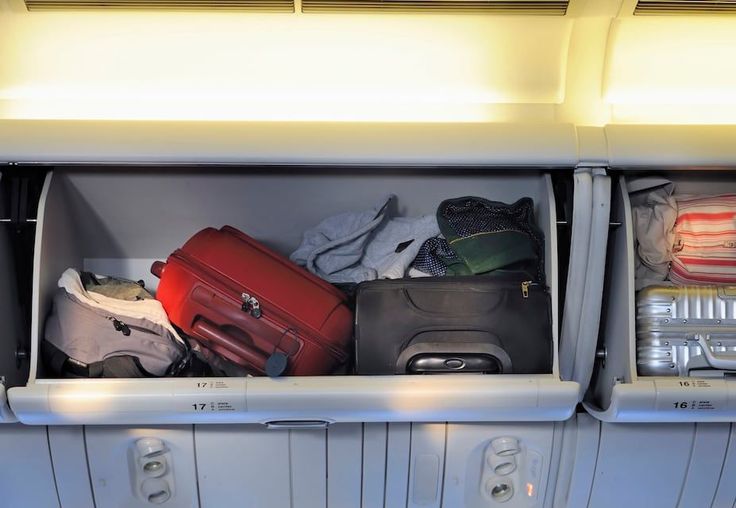 an airplane compartment filled with lots of luggage