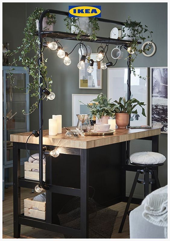 a kitchen island with plants and candles on it in front of an ikea sign