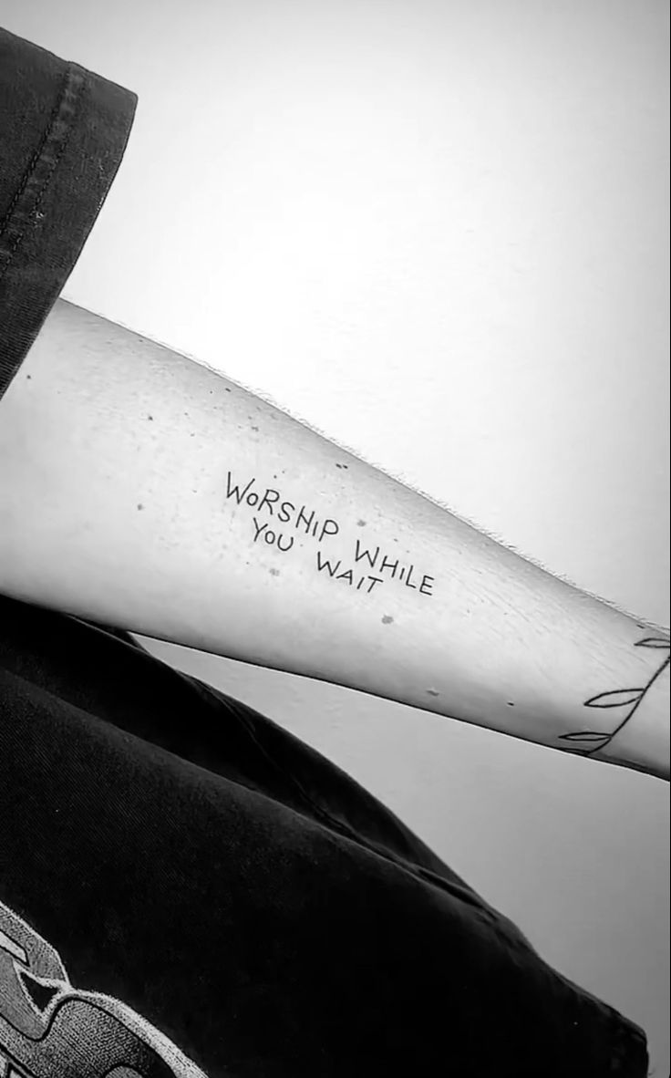 a person with a tattoo on their arm that says, worship while you want it