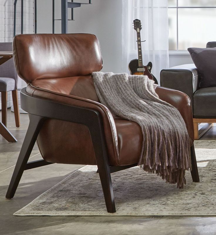 a brown leather chair with a blanket on it