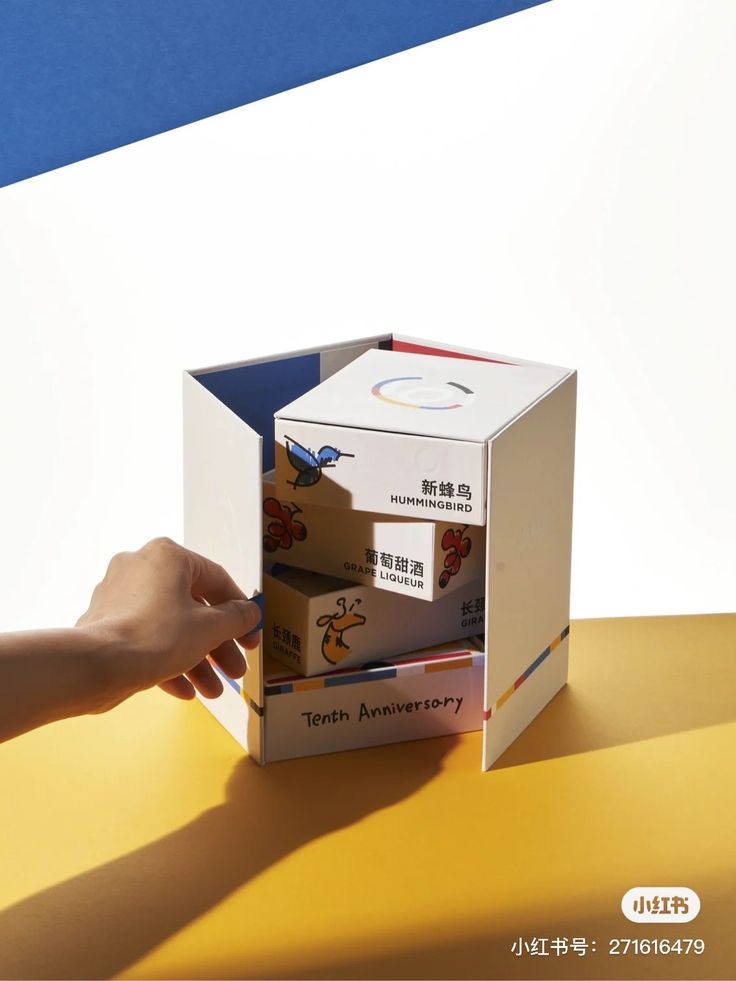 an open box sitting on top of a table next to a person's hand