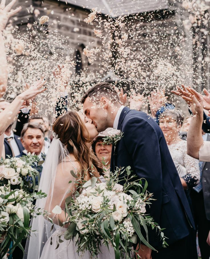 a newly married couple kissing under confetti