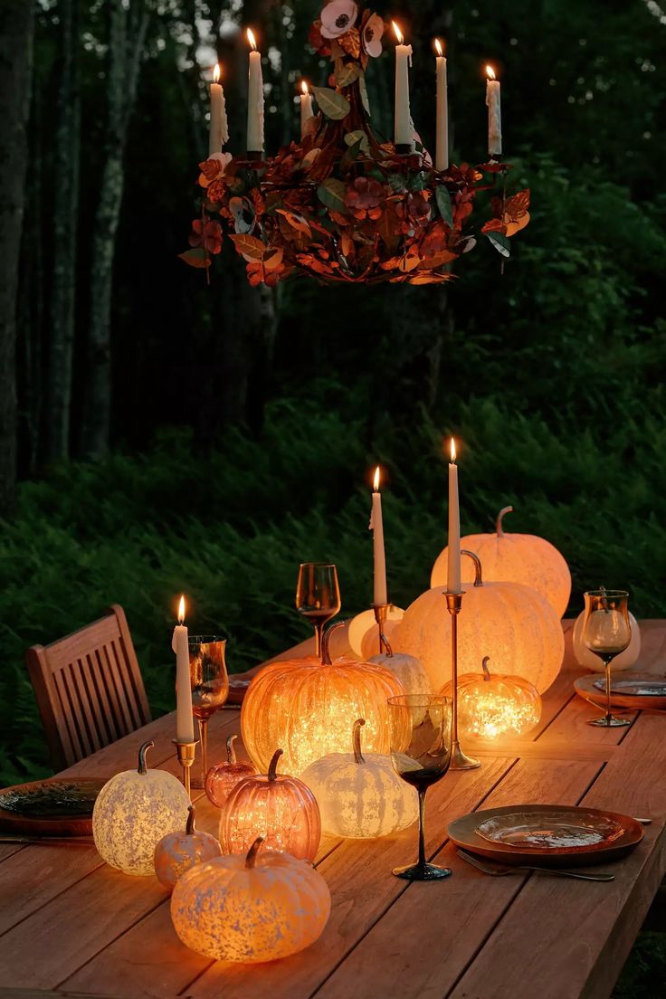 a wooden table topped with lots of lit pumpkins