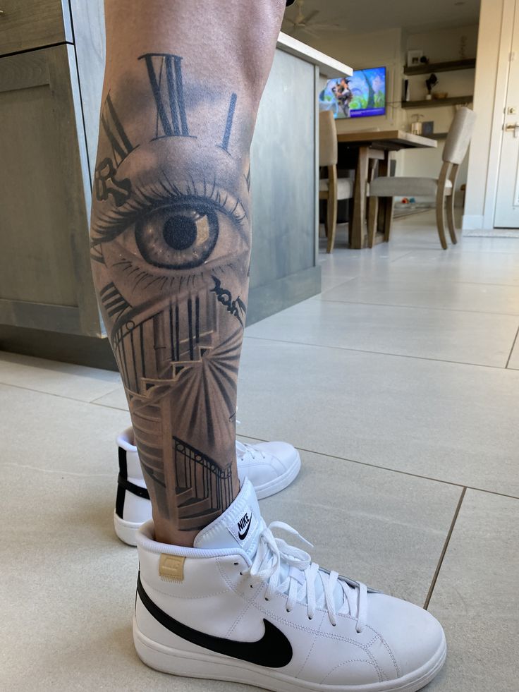 a man's leg with an eye and clock on it