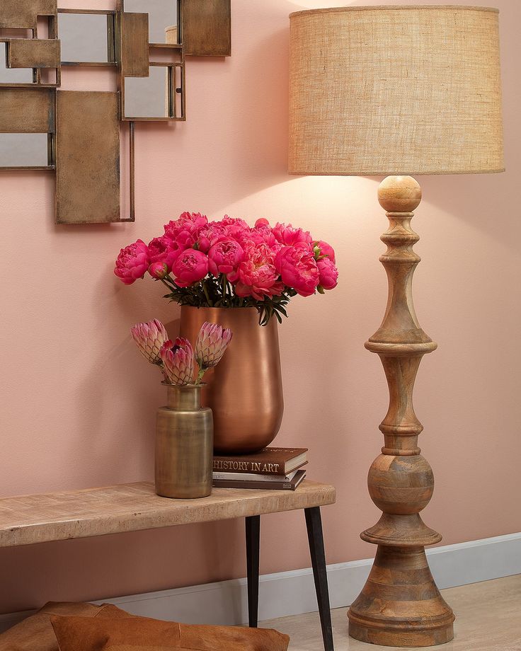 pink flowers are in vases on a table next to a lamp