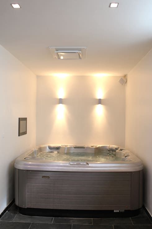 an indoor hot tub with lights above it