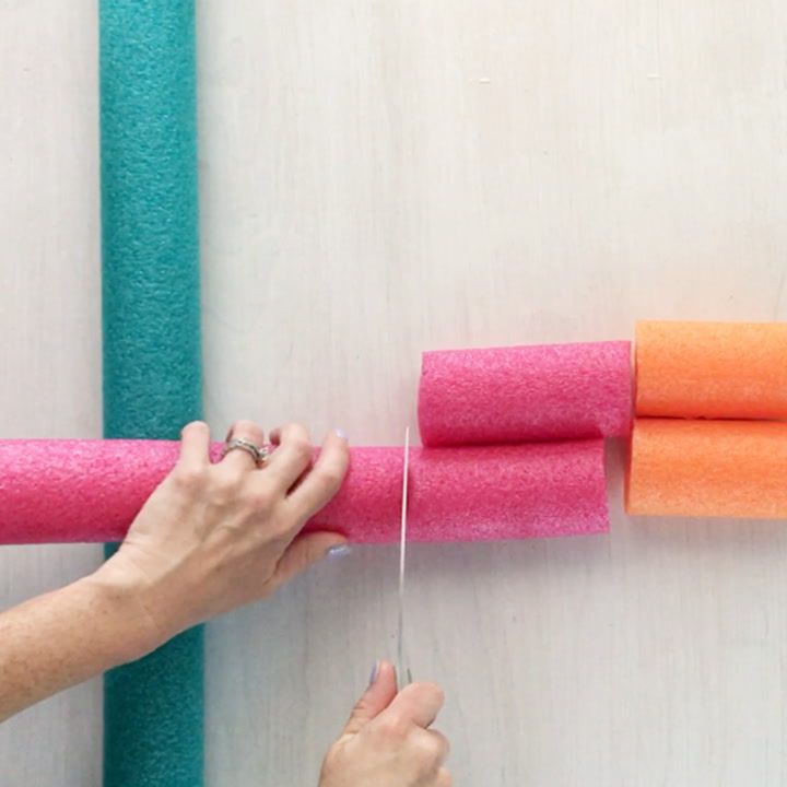 a person is sewing on some pink and orange felt rolls with scissors in front of them