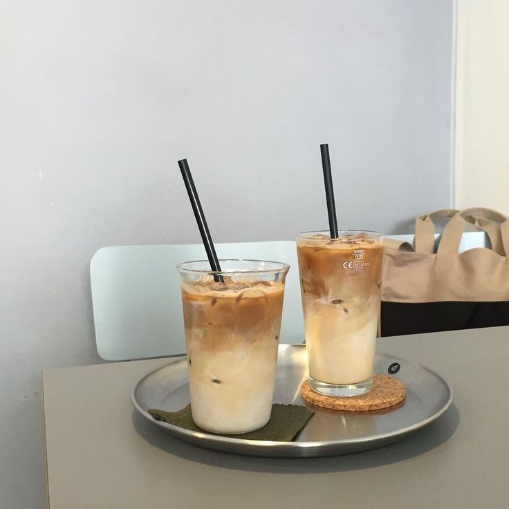 two iced drinks sitting on top of a metal tray