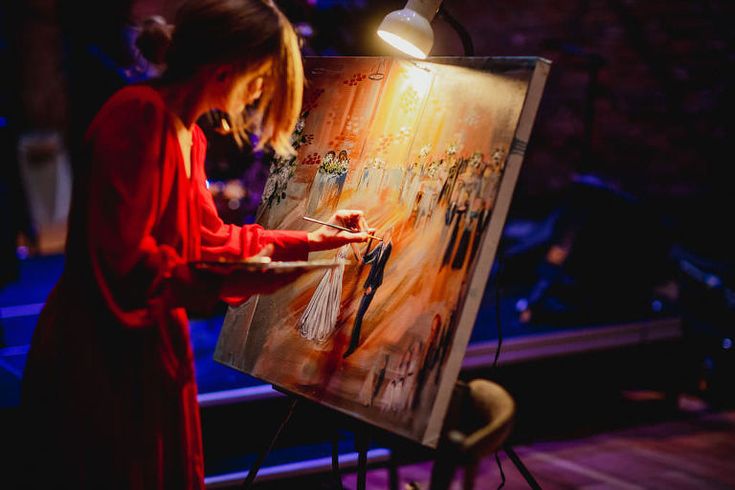 a woman is painting on an easel in the dark