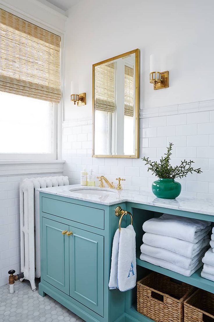 a bathroom with blue cabinets and white towels