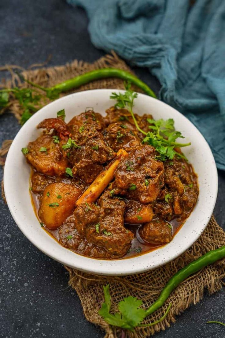 a white bowl filled with meat and vegetables