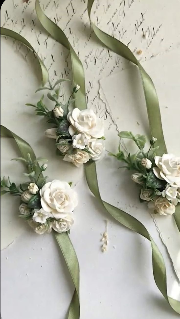 three bouquets of white flowers and green ribbons