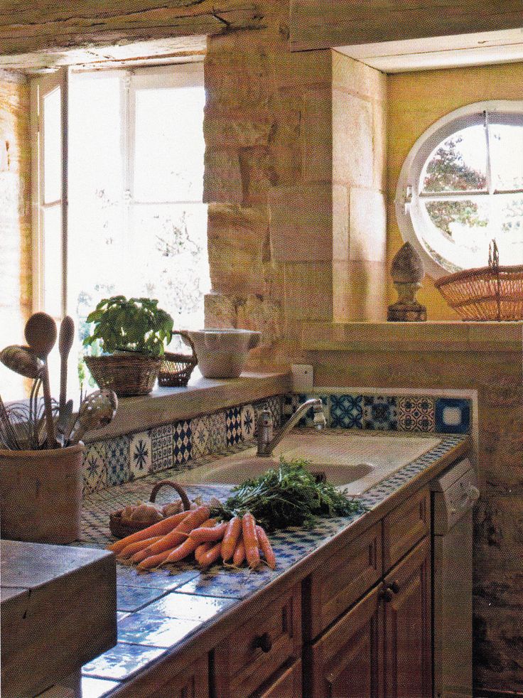 carrots and other vegetables are on the counter top in this rustic style kitchen area