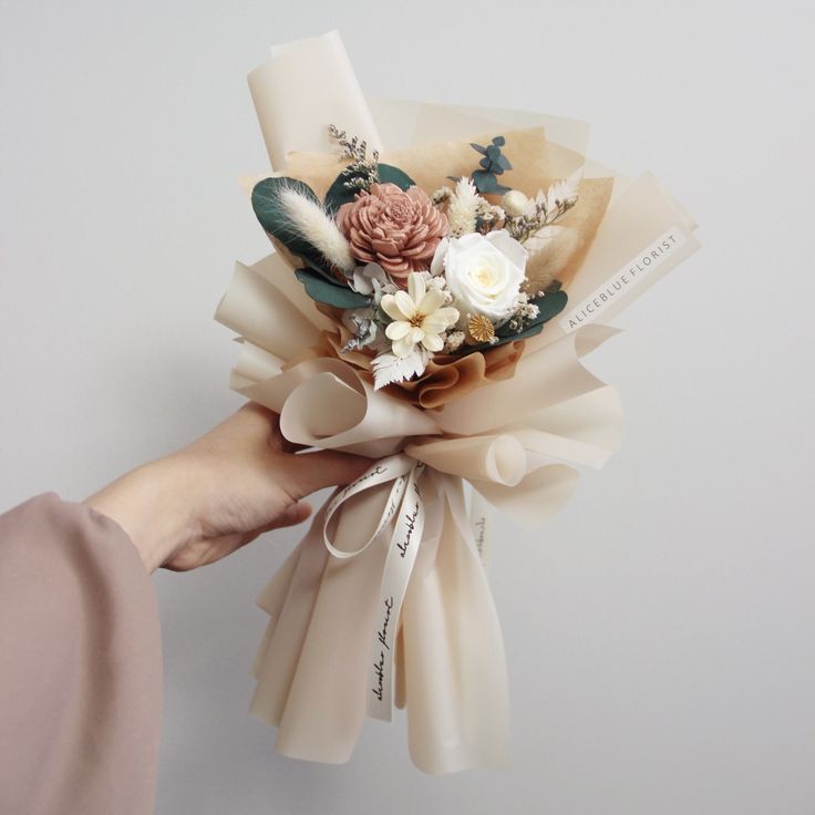 a person holding a bouquet of flowers in their hand