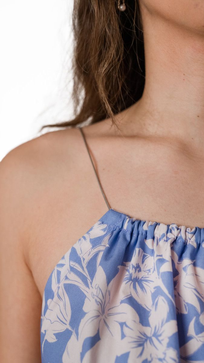 a woman wearing a blue and white dress with flowers on it