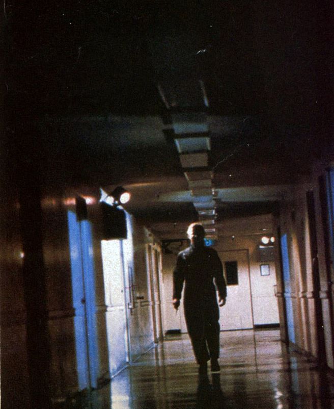 a man walking down a hallway in an office building