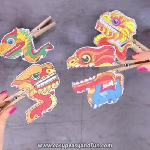 two hands holding chopsticks with different colored dragon stickers on top of them