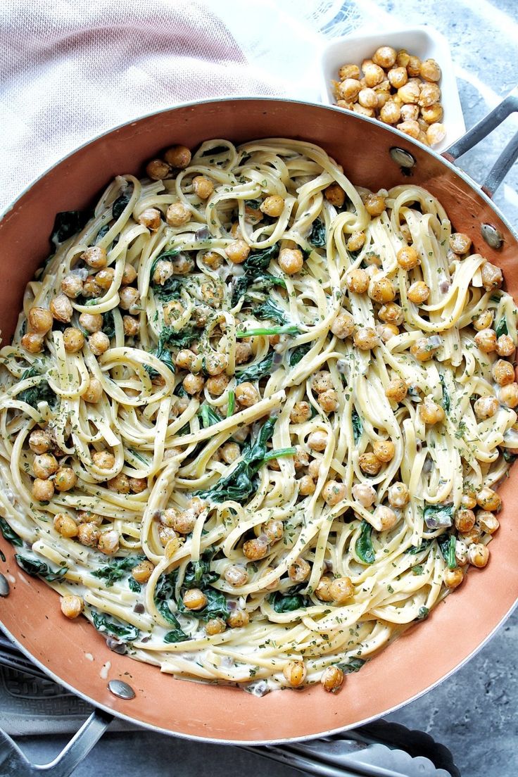 creamy chicken pasta with spinach and chickpeas in a skillet