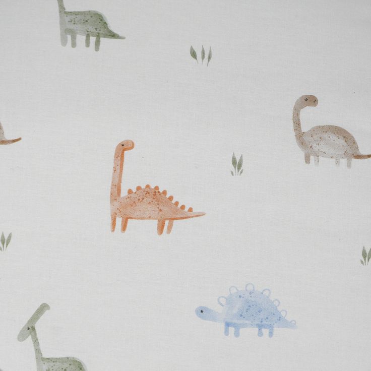 a white fabric with dinosaurs and giraffes on it