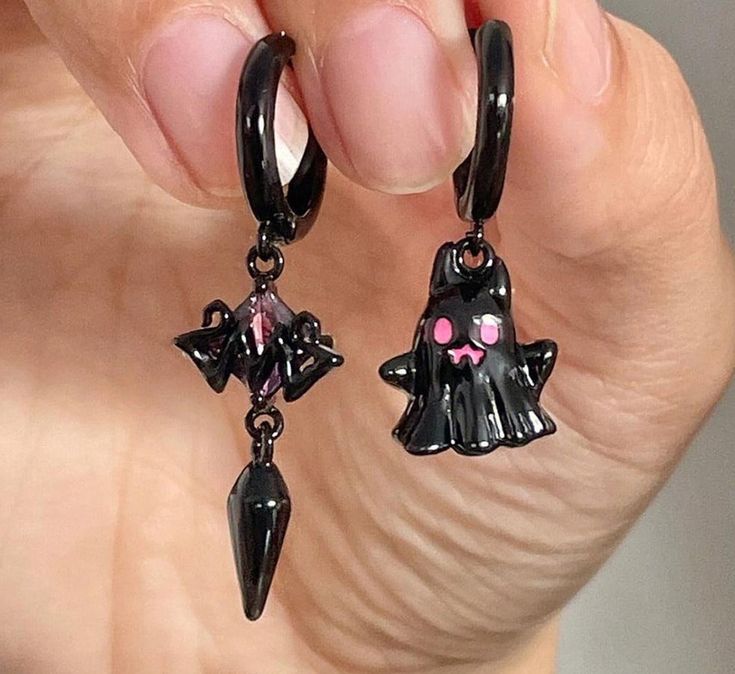 Let your spooky side shine in our Dangly Ghost Asymmetrical Earrings! Featuring intricate detailing and a unique design, these earrings will make a striking statement. Whether it's a night out or just a casual day, show off your edgy side with this hauntingly chic accessory. Edgy Dangle Earrings For Halloween, Trendy Halloween Dangle Earrings, Trendy Dangle Earrings For Halloween, Trendy Halloween Earrings As A Gift, Trendy Halloween Earrings For Gift, Whimsical Black Drop Earrings, Trendy Pierced Earrings For Halloween, Trendy Halloween Earrings, Trendy Black Halloween Earrings