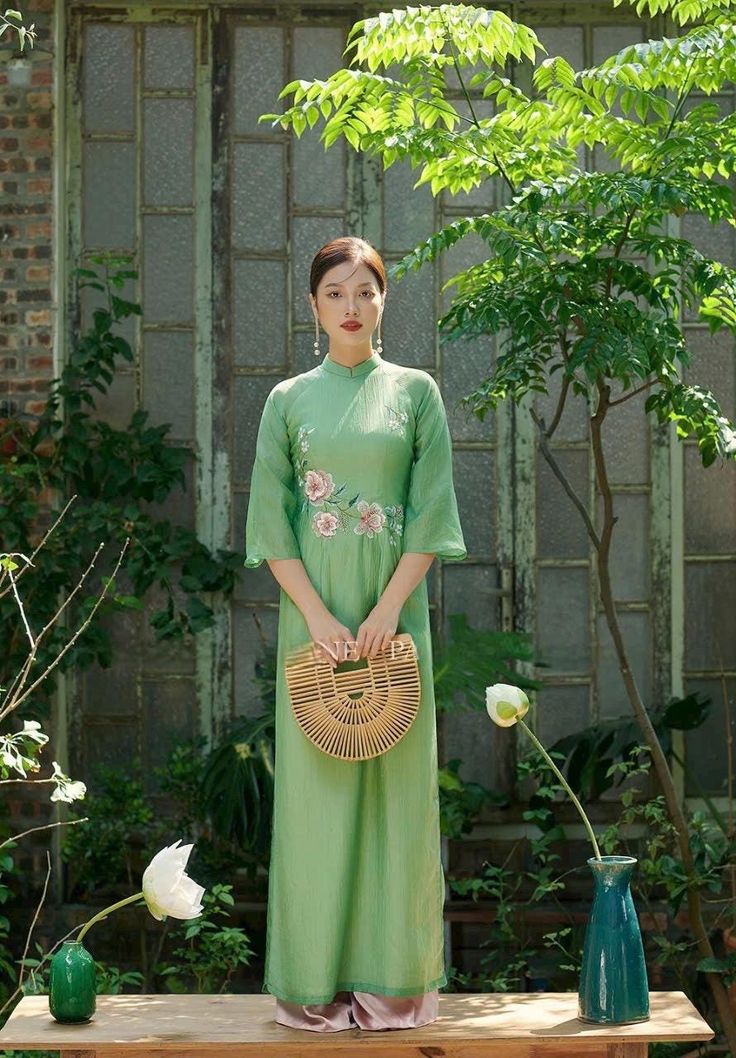 Beautiful shamock green color ao dai set accent lightly with fine embroidery of cherry blossom flowers elegant and beautiful . We pair with white pant. Traditional Vietnamese Clothing, Mint Pants, Vietnamese Clothing, Vietnamese Traditional Dress, Green Cherries, Pants Style, Fashion Baby, White Pants, Art Class