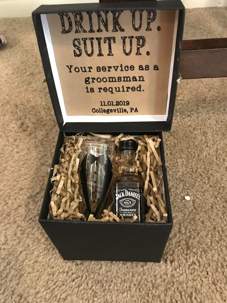 an open box with some bottles in it on the floor next to a sign that says drink up suit up