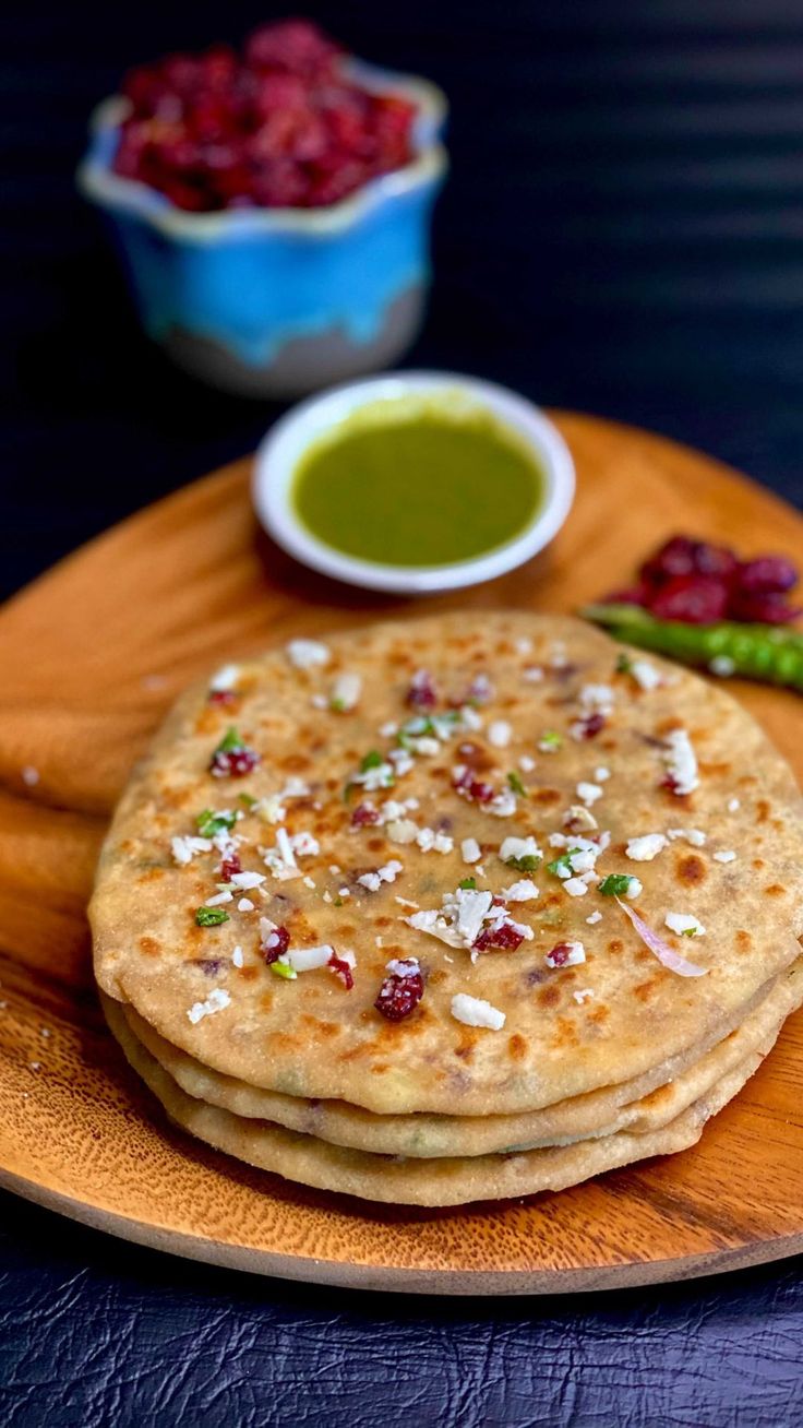 some food is on a wooden plate with green sauce