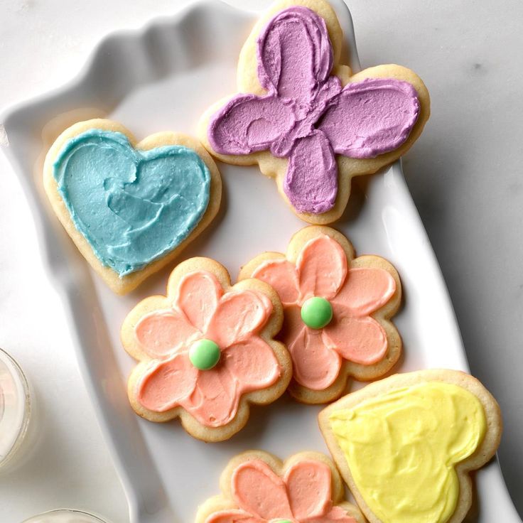 four decorated cookies sitting on top of a white plate