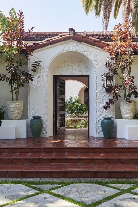 an entrance to a house with potted plants on the steps