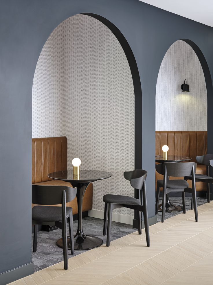 Leather banquette seating within an arch. Small round black table in front with two black chairs. Tiled floor outside of the arch and Bolon inside. Arch Booth Seating, Arch Interior Design Restaurant, Arch Office Interior, Wall Booth Seating, Office Booth Seating Design, Cafe Booth Seating Design, Booth Seating Office, Curved Booth Design, Seating Booth Design